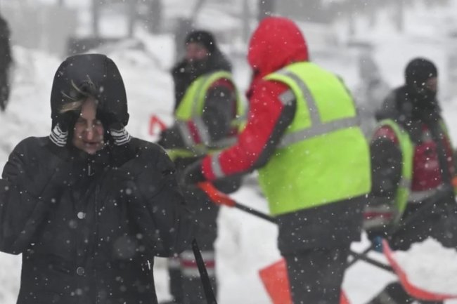 Девушка идёт по улице во время снегопада в Москве.