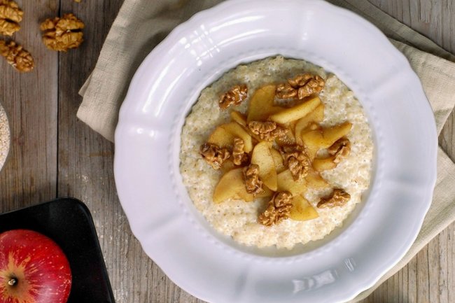 миска горячей ячневой каши с ягодами и орехами