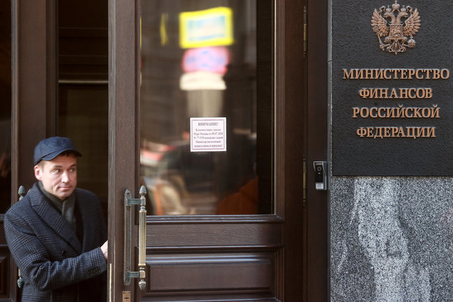 Мужчина у входа в здание Министерства финансов РФ на улице Ильинка. Министерство финансов США запретило американским гражданам осуществлять операции с Центральным банком России, Фондом национального благосостояния (ФНБ) и российским Министерством финансов. Сергей Фадеичев/ТАСС